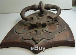 Antique Iron Door Knocker Mounted On A Wooden Shield