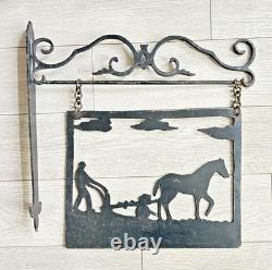 Antique wrought iron sign depicting a plowman
