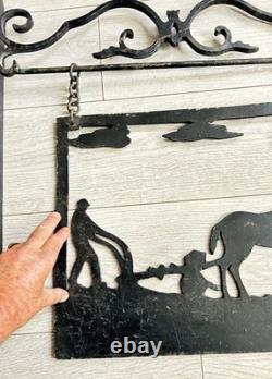 Antique wrought iron sign depicting a plowman