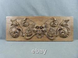 Carved oak Renaissance-style bas-relief with heads and scrolls decoration