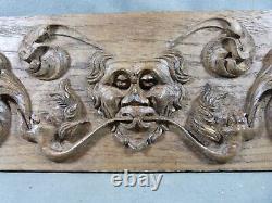 Carved oak Renaissance-style bas-relief with heads and scrolls decoration