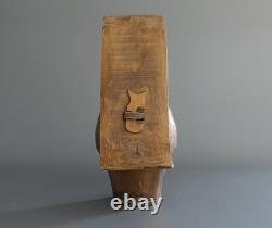Old large pastoral cowbell with curved wooden collar and leather