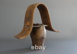 Old large pastoral cowbell with curved wooden collar and leather