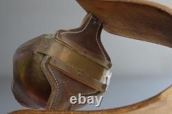Old large pastoral cowbell with curved wooden collar and leather