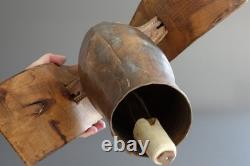 Old large pastoral cowbell with curved wooden collar and leather