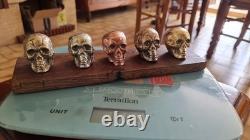 Set of small skulls in copper alloys on an oak base