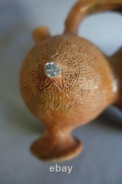Terracotta whistling vase with incised decoration